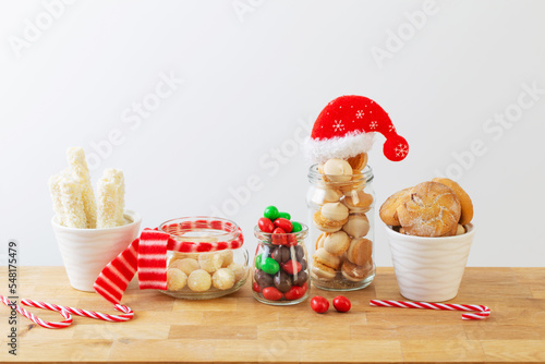 Fotografiet christmas candies and cookies  in jars on wooden shelf on white background