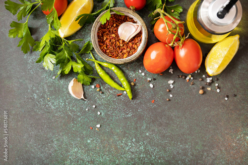 Healthy food vegetarian food background. Various herbs and spices for cooking on dark background. View from above. Copy space.