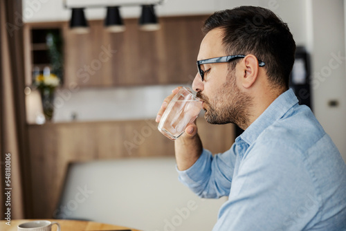 Stampa su tela Profile of thirsty man drinking fresh water at home.