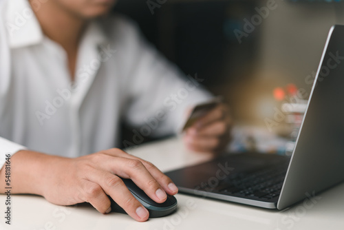 Businessman using laptop for shopping online with hand hold credit card. shopping cart, e-commerce, internet banking, spending money concept , purchase product sale. © Saknarin