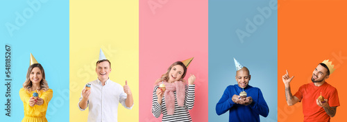Group of happy young people with birthday cupcakes on color background