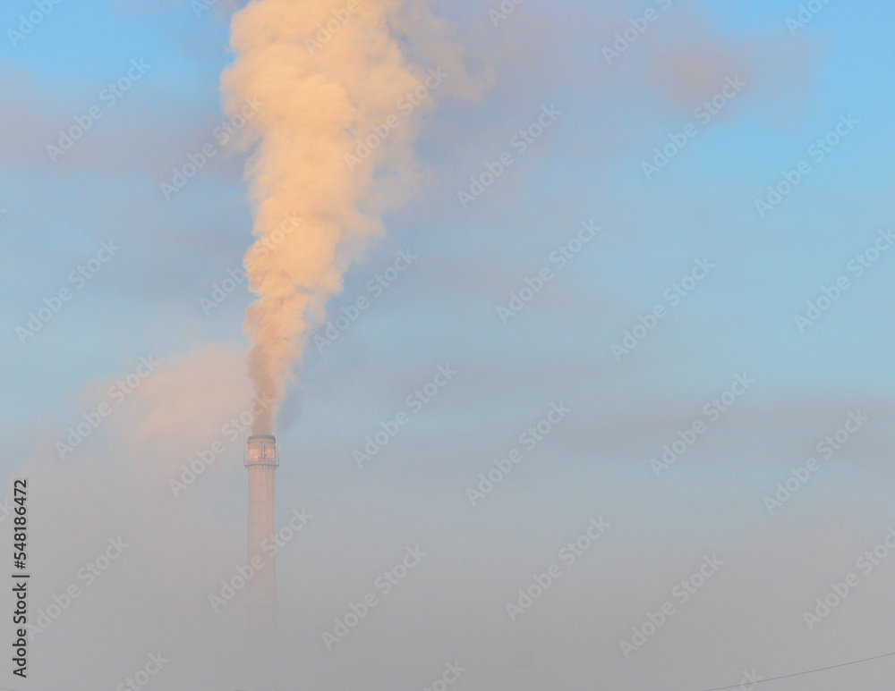 Thermal power plant in the fog, smog. Smokestack. The thermal power plant chimney and smoke.