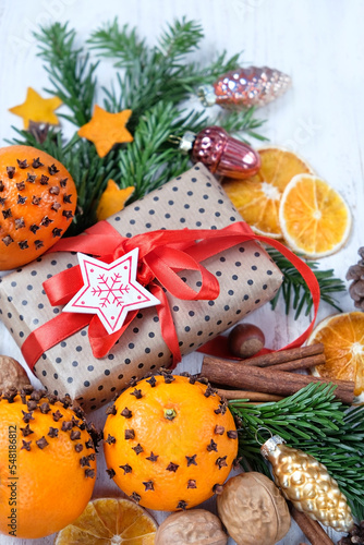 Christmas background. Gift box, fir branches, toys, cinnamon, oranges decorated cloves on wooden table close up. Christmas holiday. festive winter season