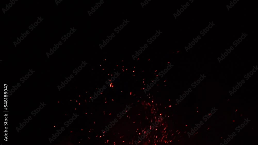 Fire flames with flying sparks on a black background. Firestorm texture. Bokeh lights on black background, shot of flying fire sparks in the air. Sparks from bonfire over dark night background. Slowmo Fire flames with flying sparks on a black background. Firestorm texture. Bokeh lights on black background, shot of flying fire sparks in the air. Sparks from bonfire over dark night background. Slowmo