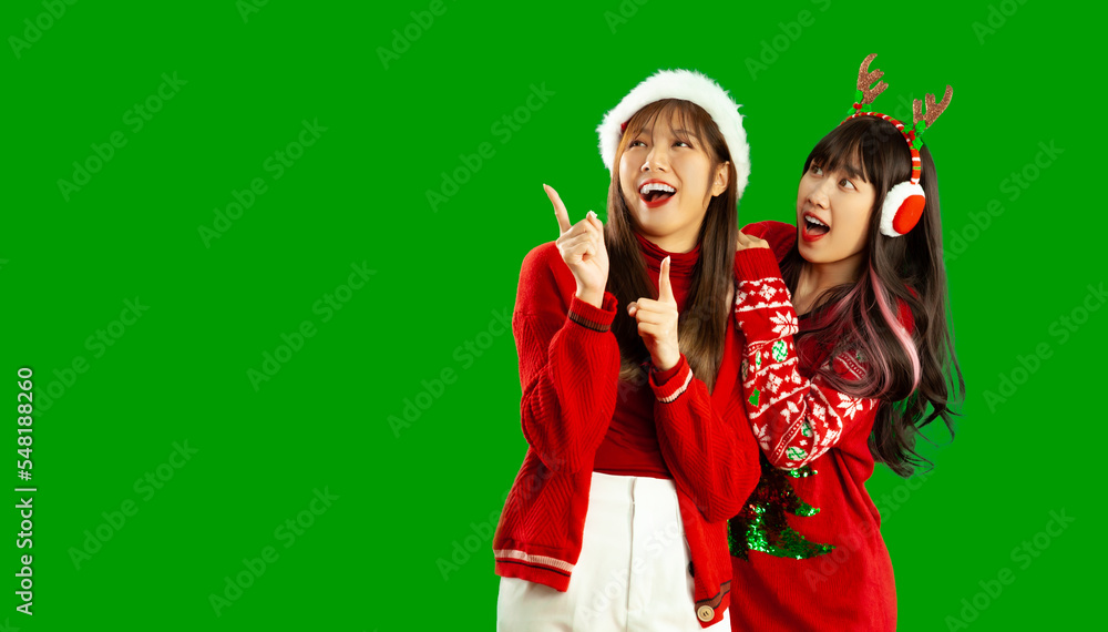 Young asian lesbian lgbt in Christmas theme costume red and white posing finger pointing green screen background. Young asian lesbian lgbt in Christmas theme costume red and white posing finger pointing green screen background.