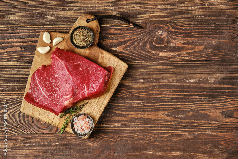 Overhead view of raw top side beef steak on wooden tabletop Overhead view of raw top side beef steak on wooden tabletop