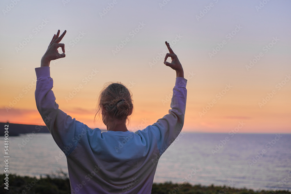attractive woman meditating and performing yoga breaths at sunset. no recognizable face attractive woman meditating and performing yoga breaths at sunset. no recognizable face