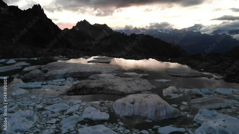 Aerial flyover above a glacier lake full of melted icebergs in remote parts of the Swiss Alps during sunset Aerial flyover above a glacier lake full of melted icebergs in remote parts of the Swiss Alps during sunset
