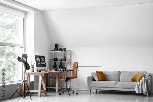 Interior of light office with photographer's workplace, shelving unit and equipment © Pixel-Shot