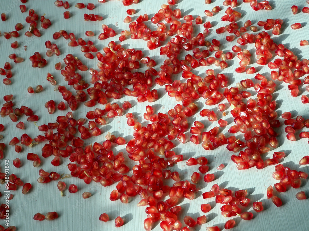 Heap of pomegranate seeds on a white wooden background Heap of pomegranate seeds on a white wooden background
