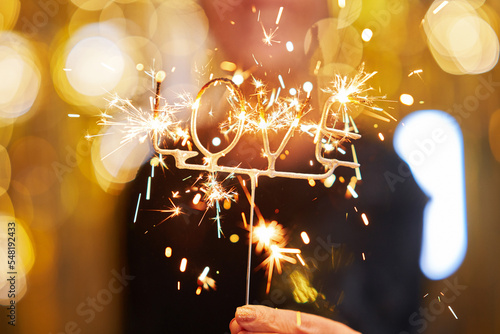 Photography Young woman holding love sparkle over gold background