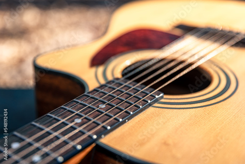 Close-up, classical acoustic guitar, soft focus in daylight.