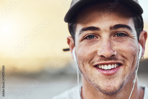 Earphones, smile and face portrait of a man in the city listening to music with a positive mindset. Happy, young and handsome guy streaming audio, radio or podcast in an urban town with mockup space.
