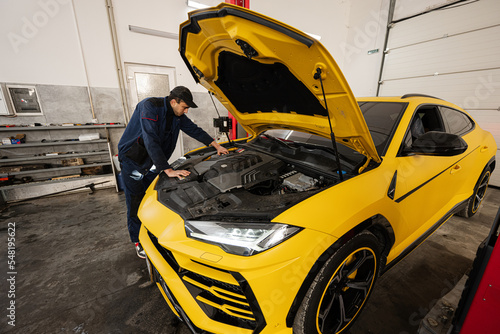 Mechanic open hood of yellow sport car suv. © AS Photo Family
