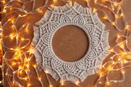 Christmas decor. Macrame wreath for Christmas and the new year on cristmas  lightes background. Natural 100% cotton thread. Eco decor for home photo