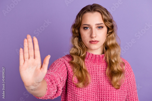 Lady making stop gesture with her palm on bright color background