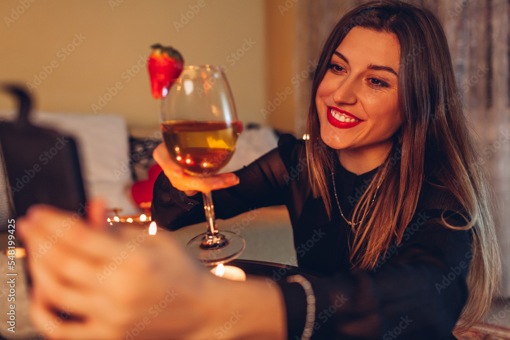 Valentines Day online remote celebration at home. Happy woman waving her boyfriend. Video chat with wine glass Valentines Day online remote celebration at home. Happy woman waving her boyfriend. Video chat with wine glass