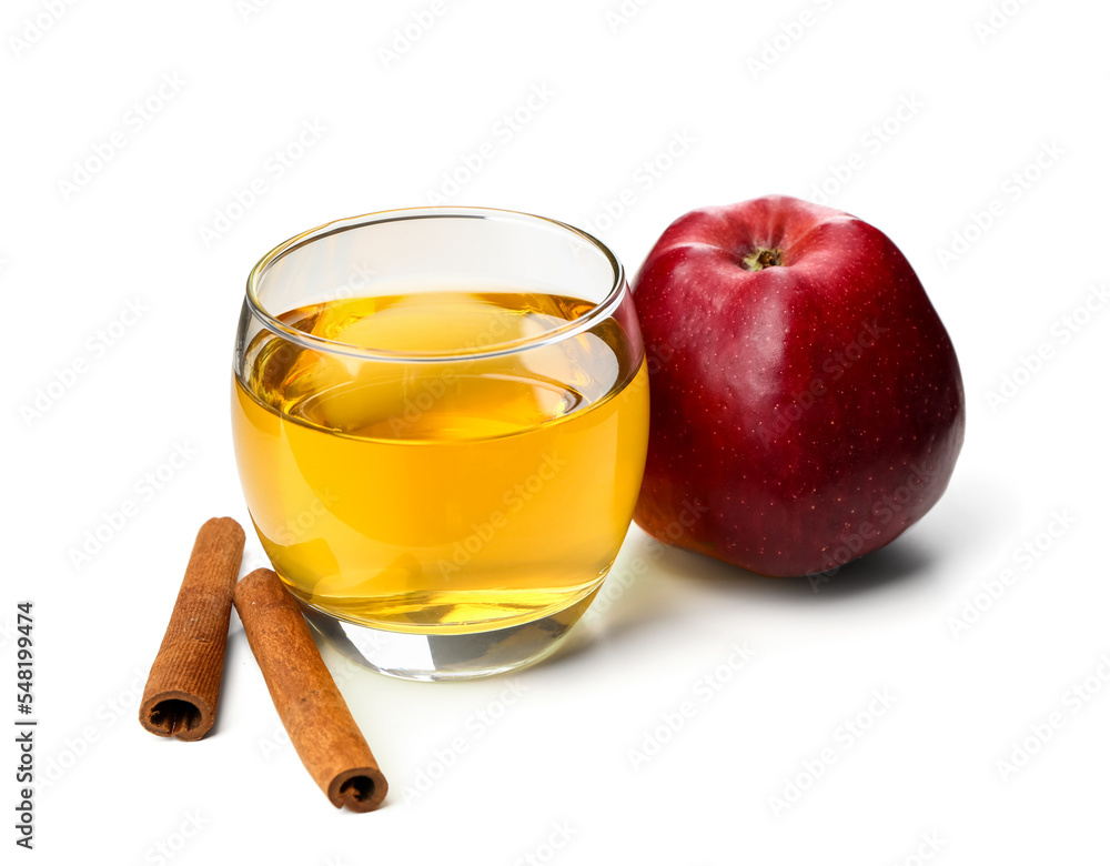 Ripe apple, glass of fresh juice and cinnamon sticks on white background Ripe apple, glass of fresh juice and cinnamon sticks on white background