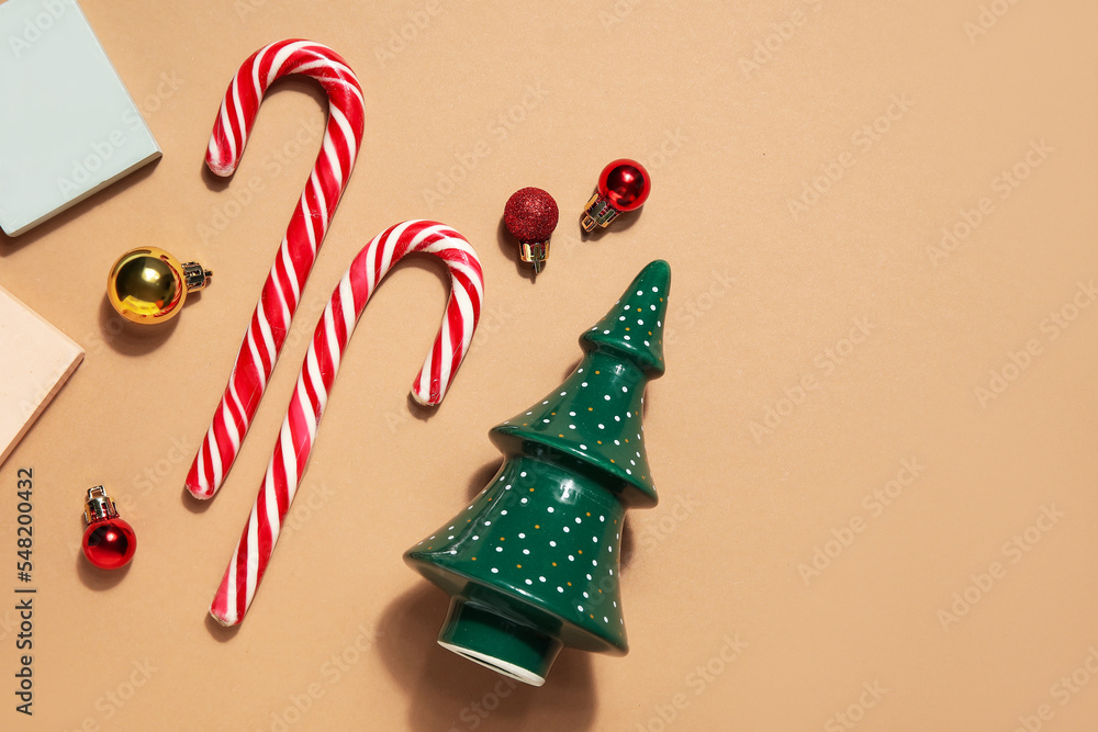 Decorative Christmas tree with podiums, candy canes and balls on beige background