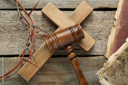 Фотография Judge gavel, cross and crown of thorns on wooden table, flat lay