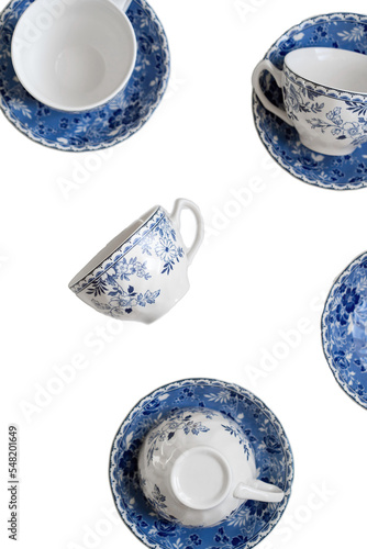 Ceramic saucers with a cup for tea in blue with flowers. New luxury elegance dinnerware. Trendy plate. Flat lay view. Transparent background.