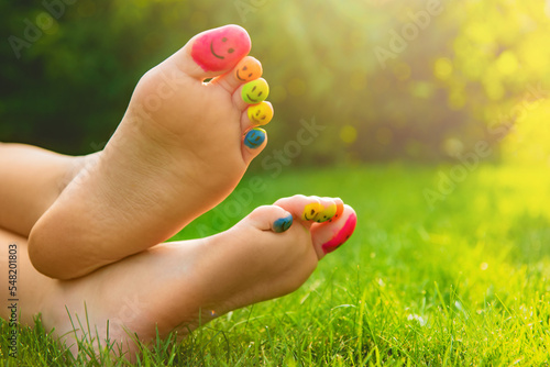Canvastavla Teenage girl with smiling faces drawn on toes outdoors, closeup