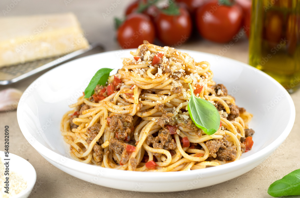 Pasta with spaghetti bolognese with fresh basil on a light background. Spaghetti with meat ragout is a traditional Italian food. Selective focus. Pasta with spaghetti bolognese with fresh basil on a light background. Spaghetti with meat ragout is a traditional Italian food. Selective focus.