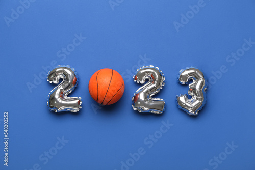 Figure 2023 made of balloons and ball on blue background photo