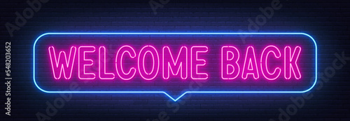 Welcome Back neon sign in the speech bubble on brick wall background.