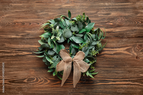 Stylish Christmas wreath on wooden background