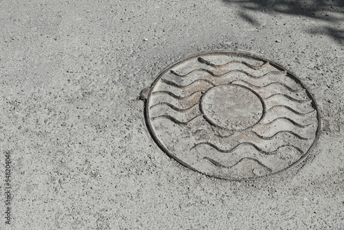 Metal sewer hatch on asphalt outdoors, space for text