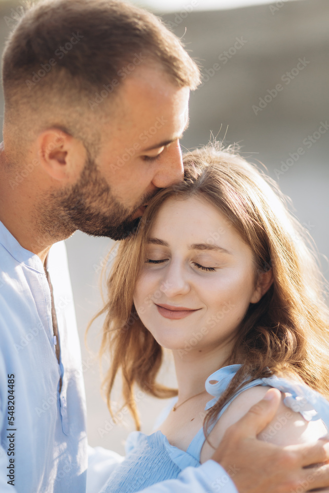 Portrait of a lovely couple standing together on the greenfield. Happy couple expecting a baby, young family concept Portrait of a lovely couple standing together on the greenfield. Happy couple expecting a baby, young family concept