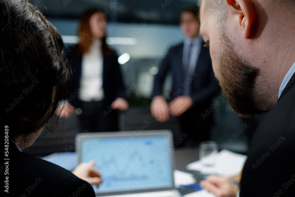 Traders monitoring stock market chart in office Traders monitoring stock market chart in office