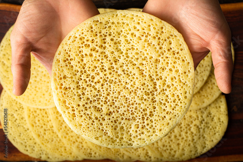 A hand taking a Moroccan pancake, baghrir typical moroccan breakfast dessert