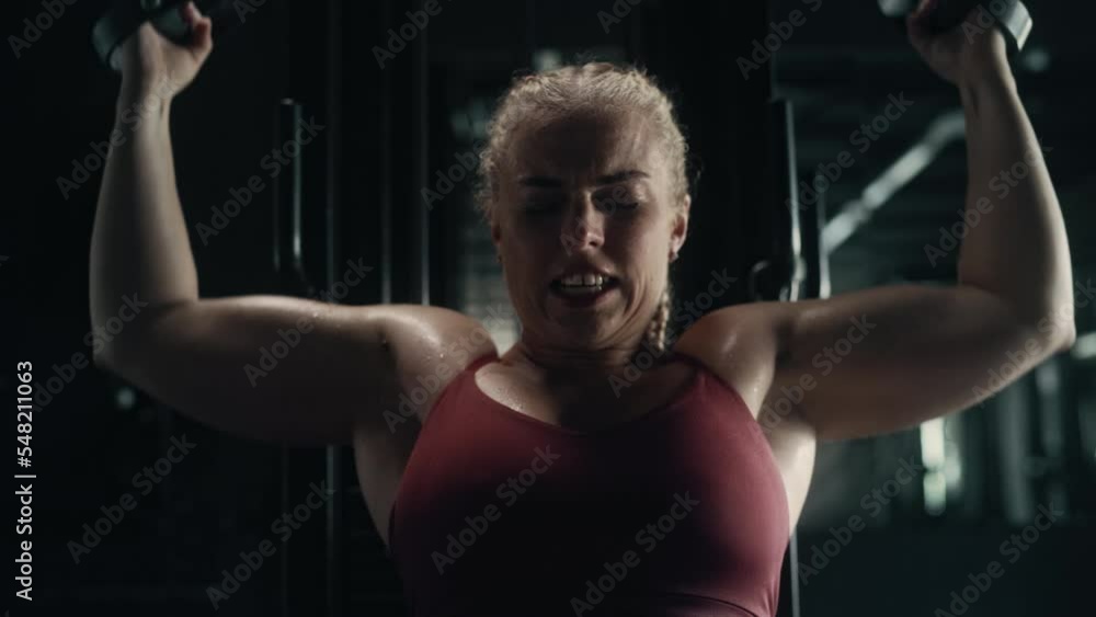 A Sweating Determined Female Weightlifter Finishing her Training and