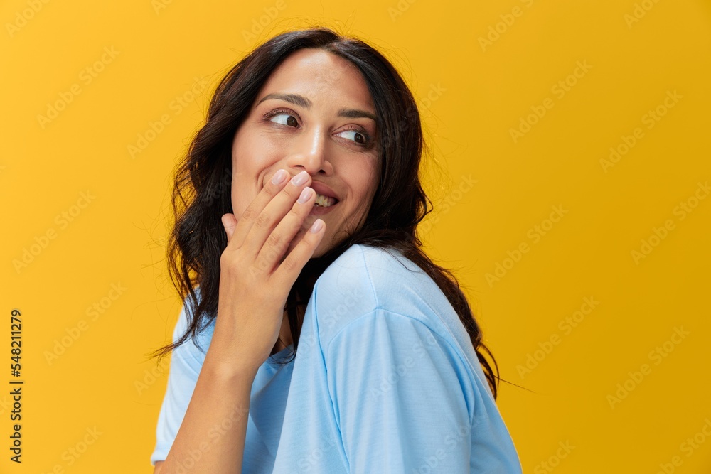 Woman signal smile with teeth emotion portrait in blue t-shirt on yellow background, hands up, surprise, lifestyle, copy space Woman signal smile with teeth emotion portrait in blue t-shirt on yellow background, hands up, surprise, lifestyle, copy space