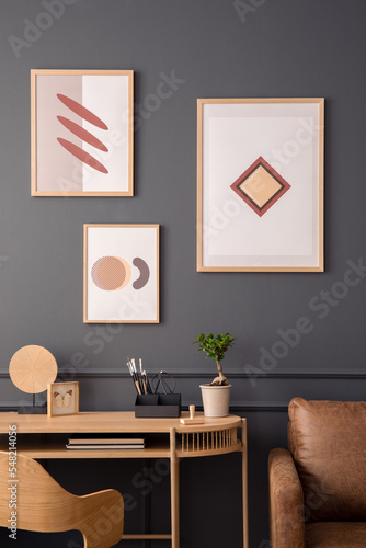 Interior design of stylish living room interior with mock up poster frame, wooden desk, brown sofa, modern armchair, plant in flowerpot, books and personal accessories. Home decor. Template. © FollowTheFlow