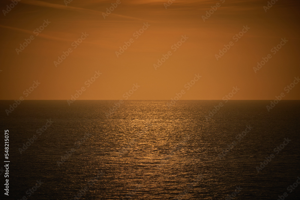 Naklejka premium A photograph of a moody dark orange and brown sea view