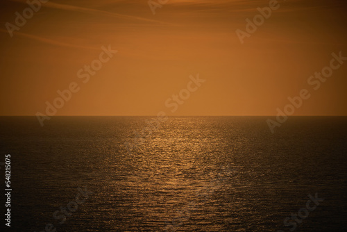 A photograph of a moody dark orange and brown sea view