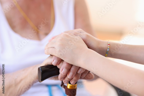 Young woman putting hands on granny hands, supporting gesture
