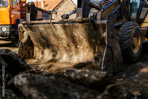 Close up of excavator digging asphalt on construction site.