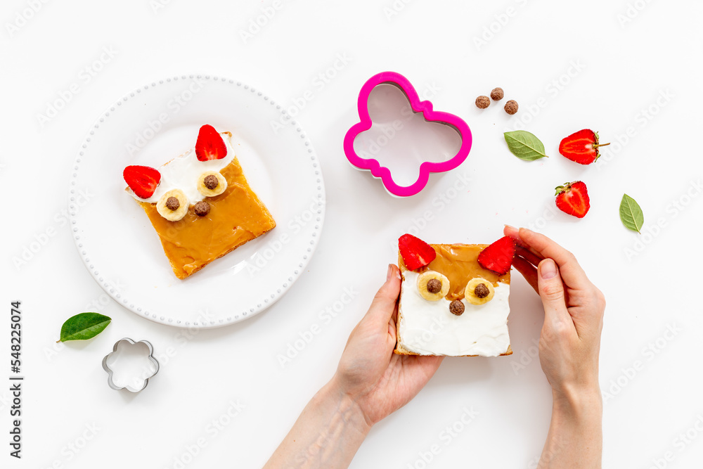 Fototapeta premium Fox faces sandwiches for funny kids breakfast. Sandwich made from peanut butter and strawberries