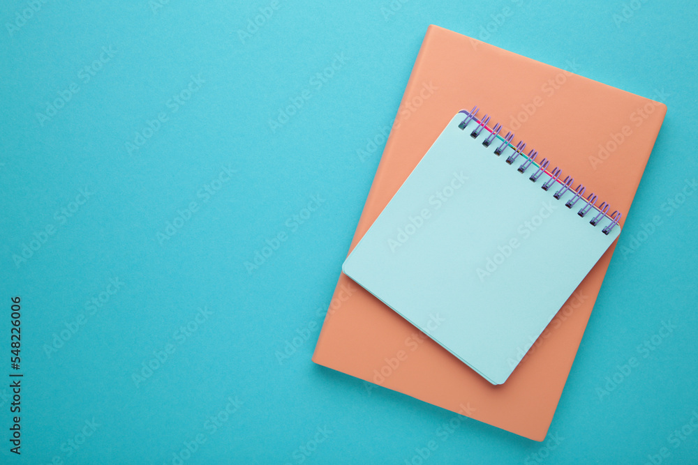 Blank paper notebook on blue background. Office desk table concept. Blank paper notebook on blue background. Office desk table concept.