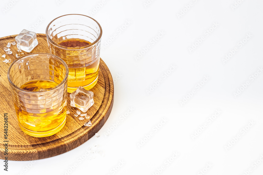 Glass of strong alcoholic drink whiskey with ice. Alcohol background