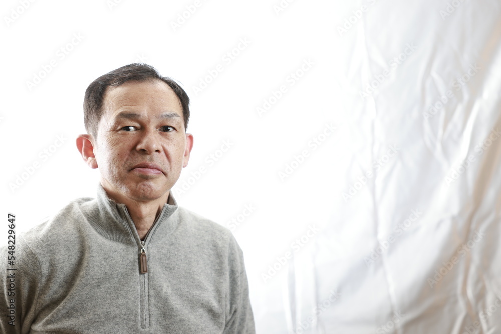 Middle-aged Japanese man in gray turtleneck wool sweater. Concept image of Warm Biz, stability in daily life, and sustainable living. Middle-aged Japanese man in gray turtleneck wool sweater. Concept image of Warm Biz, stability in daily life, and sustainable living.