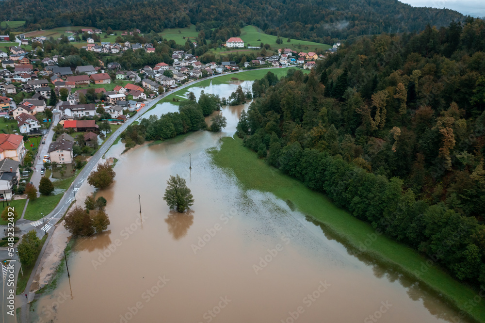 Extensive deluge across Europe, flooded mountain valley, near the households area and traffic ways, drone shot. Extreme climate event.