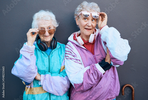 Bilde på lerret Fashion, funky and friends with a senior woman pair standing outdoor on a gray wall background together