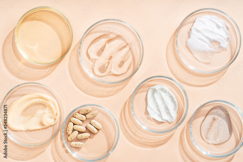 Fototapeta premium Natural medicine glass labware, petri dishes, cream jars, scrub, aromatic oils. Natural cosmetic background, healthy lifestyle.