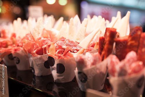 sausage, salami, fuet in craft paper bag at market counter photo