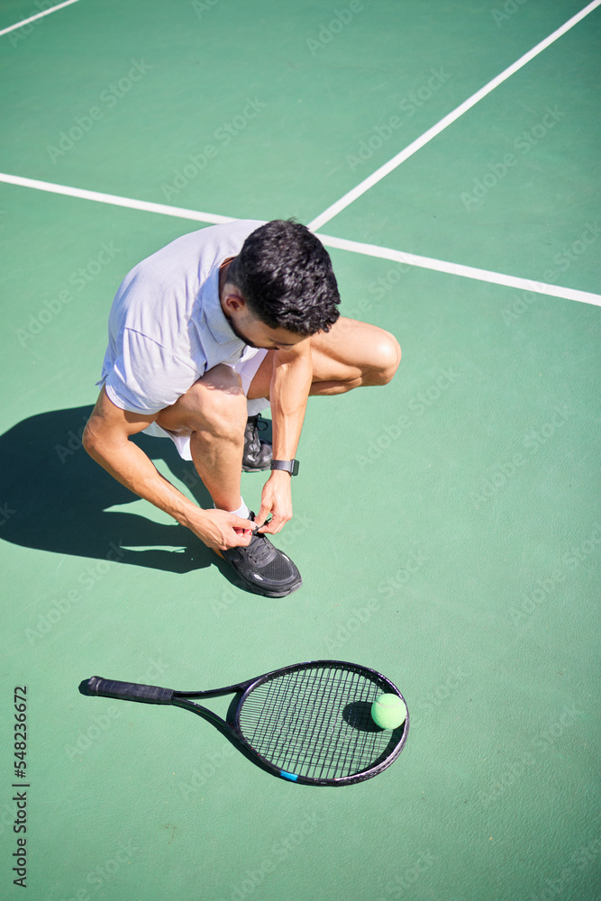 Tennis, tie and man with shoes on a court for sports training, fitness exercise or cardio workout in summer in Spain. Wellness, athlete or tennis player ready to start playing a game on tennis court